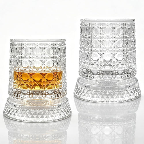 Two crystal-style rotating whiskey glasses on illuminated coasters
